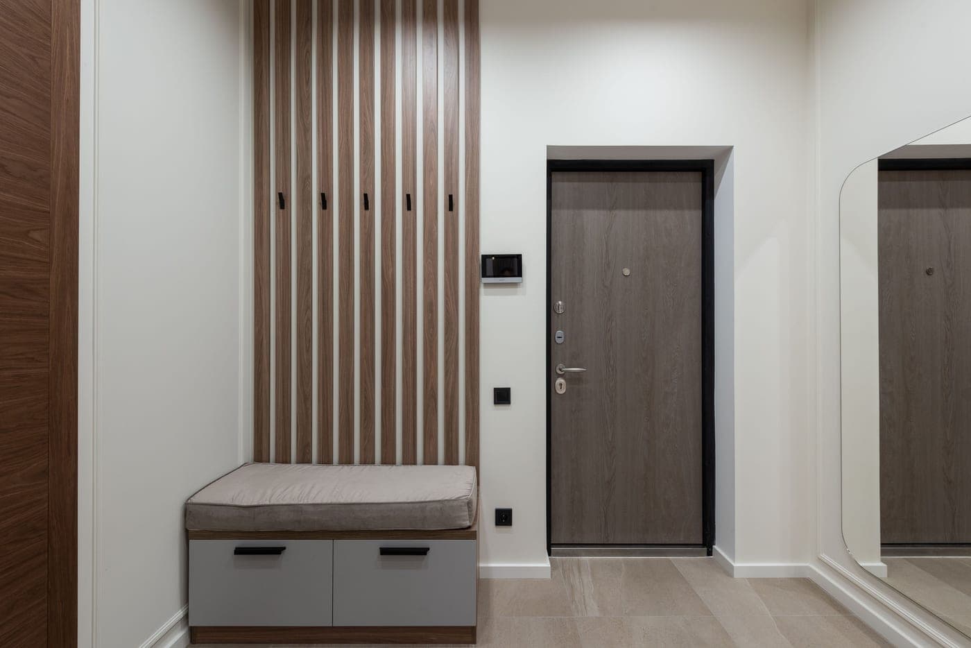 A modern apartment hall with a wooden cabinet and a large mirror