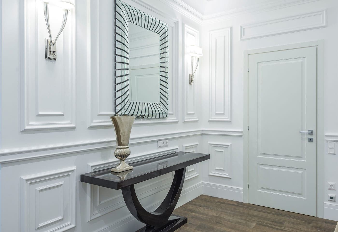 A narrow hallway with a console table and a mirror against one wall