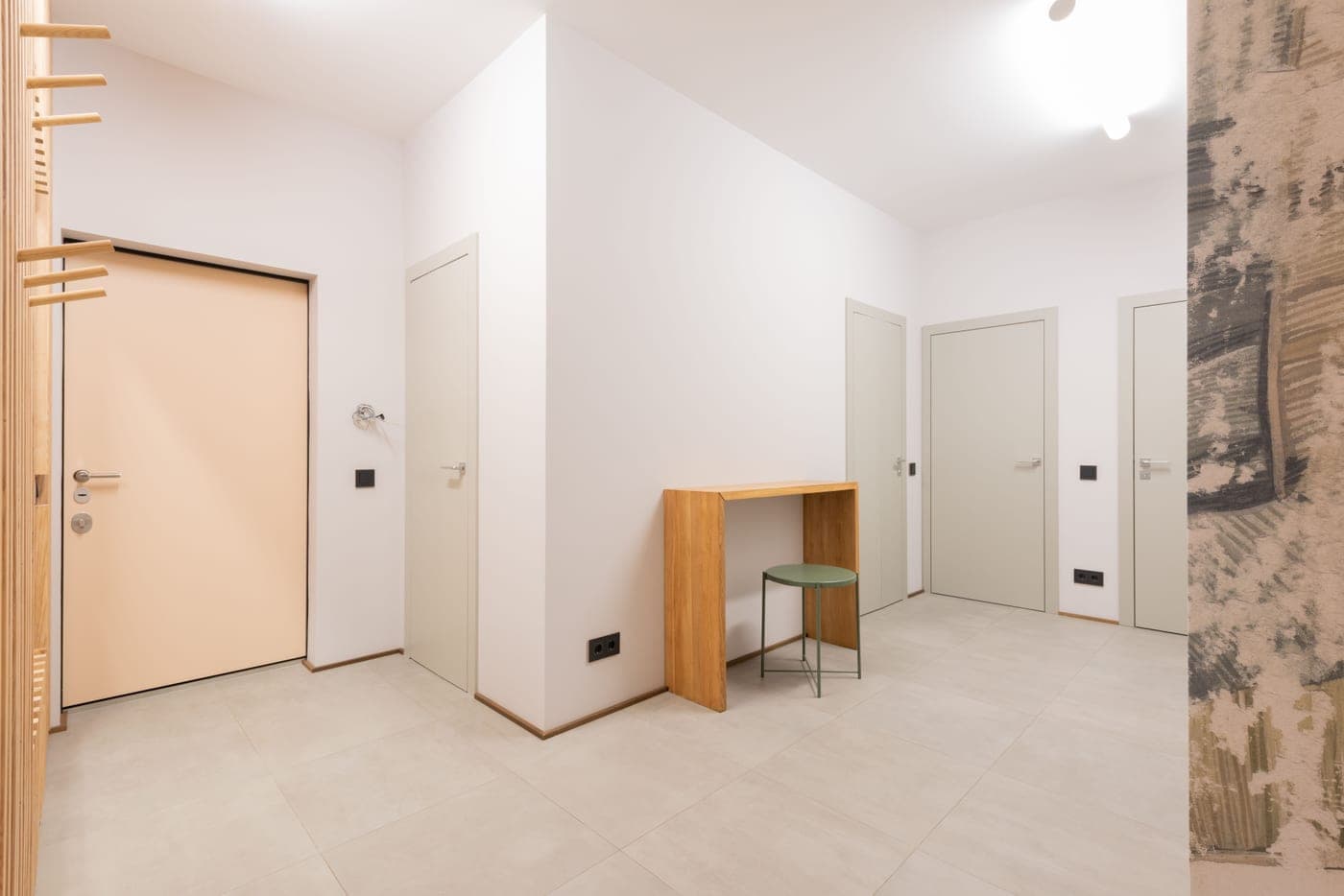 An upholstered ottoman stool positioned beside a front door