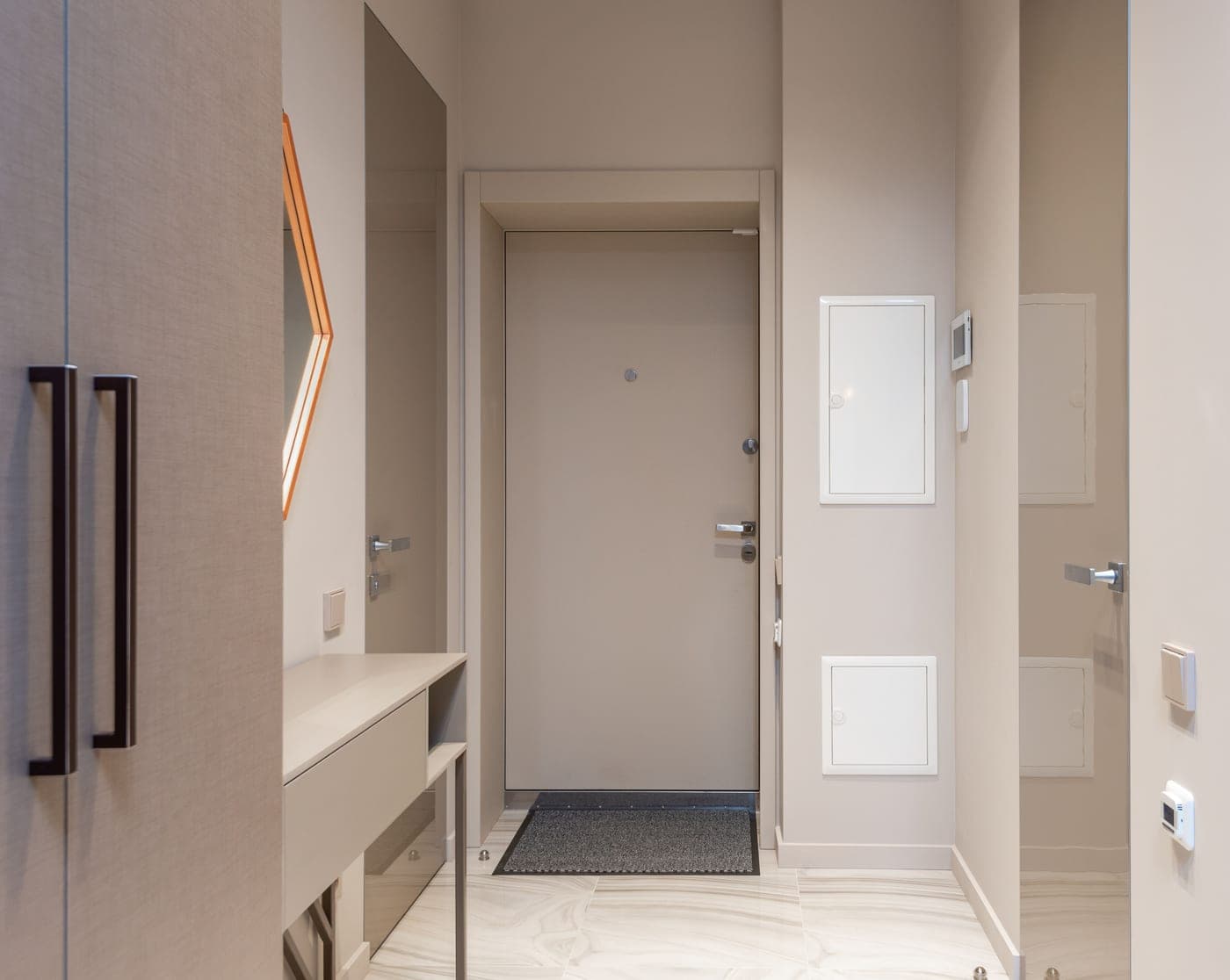 A light corridor with doors, a low cabinet and a rug on the floor
