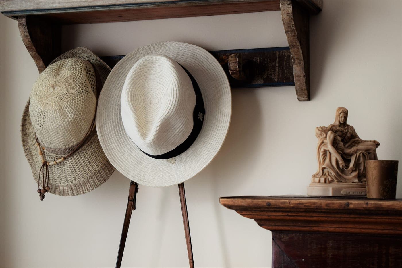 A wall-mounted coat rack with hats and jackets hanging from it