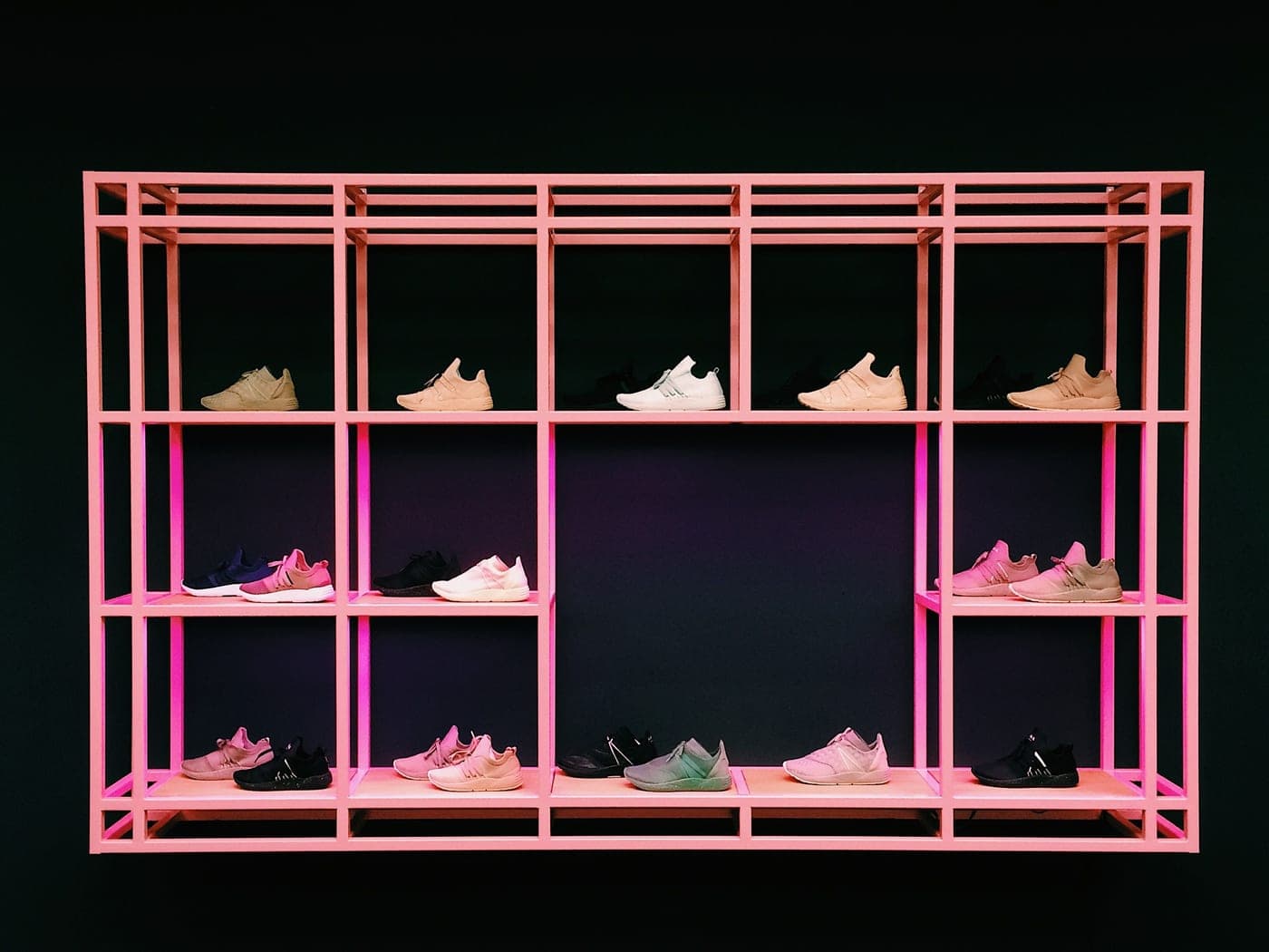 An open shoe rack with sneakers arranged on its shelves