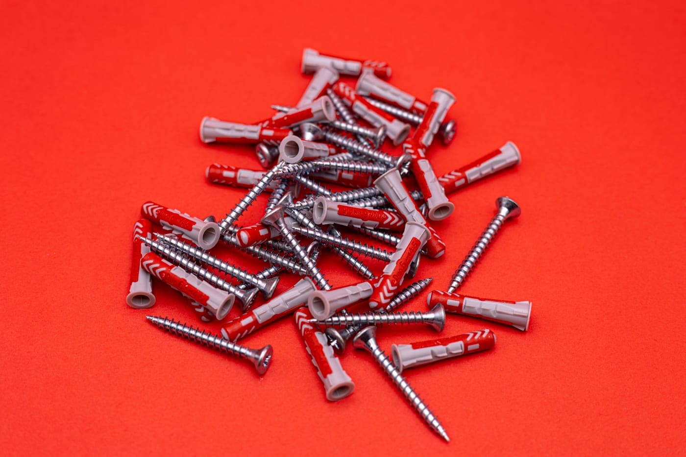 A drill and wall anchors laid out for fixing furniture to a wall