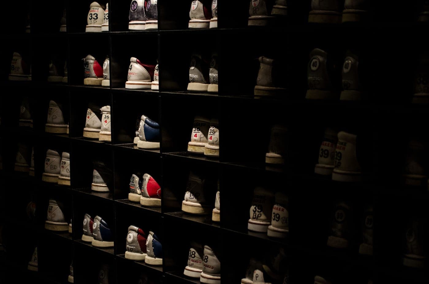 A large collection of shoes arranged on open shelving