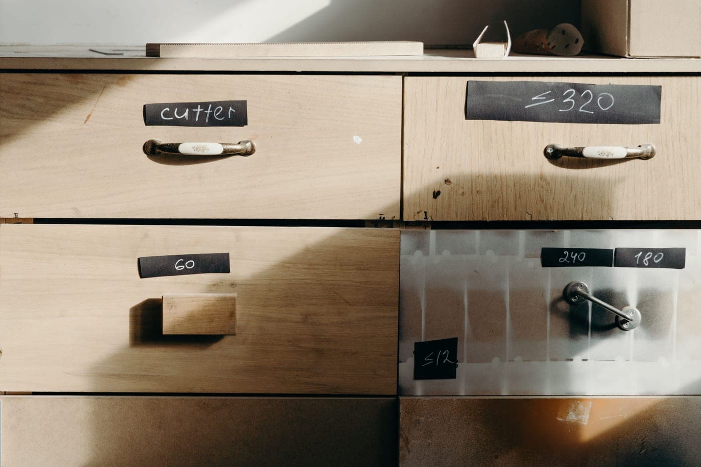 Detail of a cabinet with a tilting drawer front partly open
