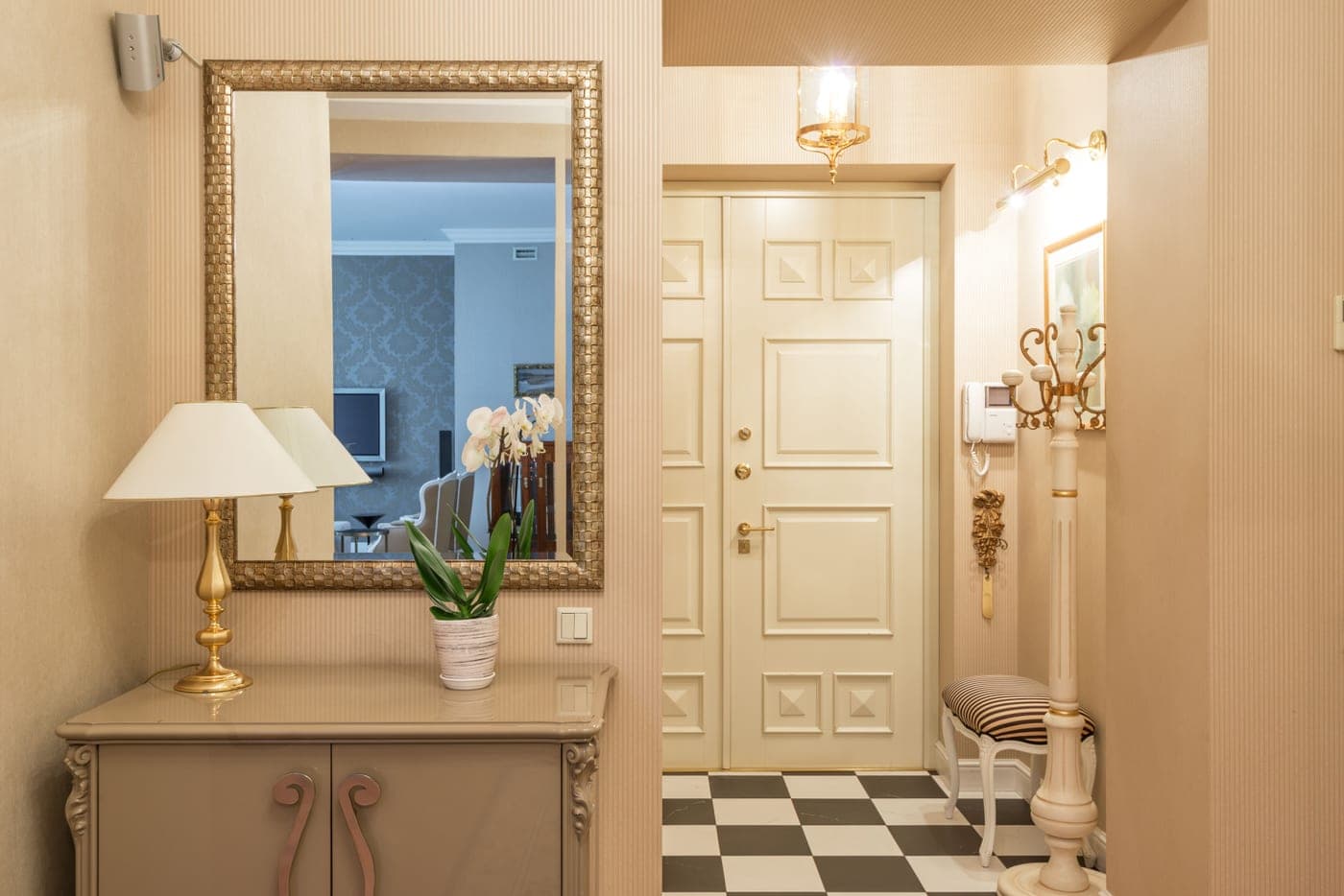 An apartment entrance corridor with a vintage coat rack and a lamp