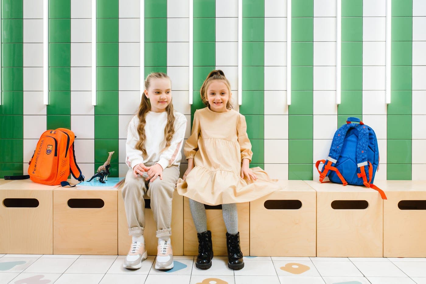 Children's shoes and backpacks beside a front door
