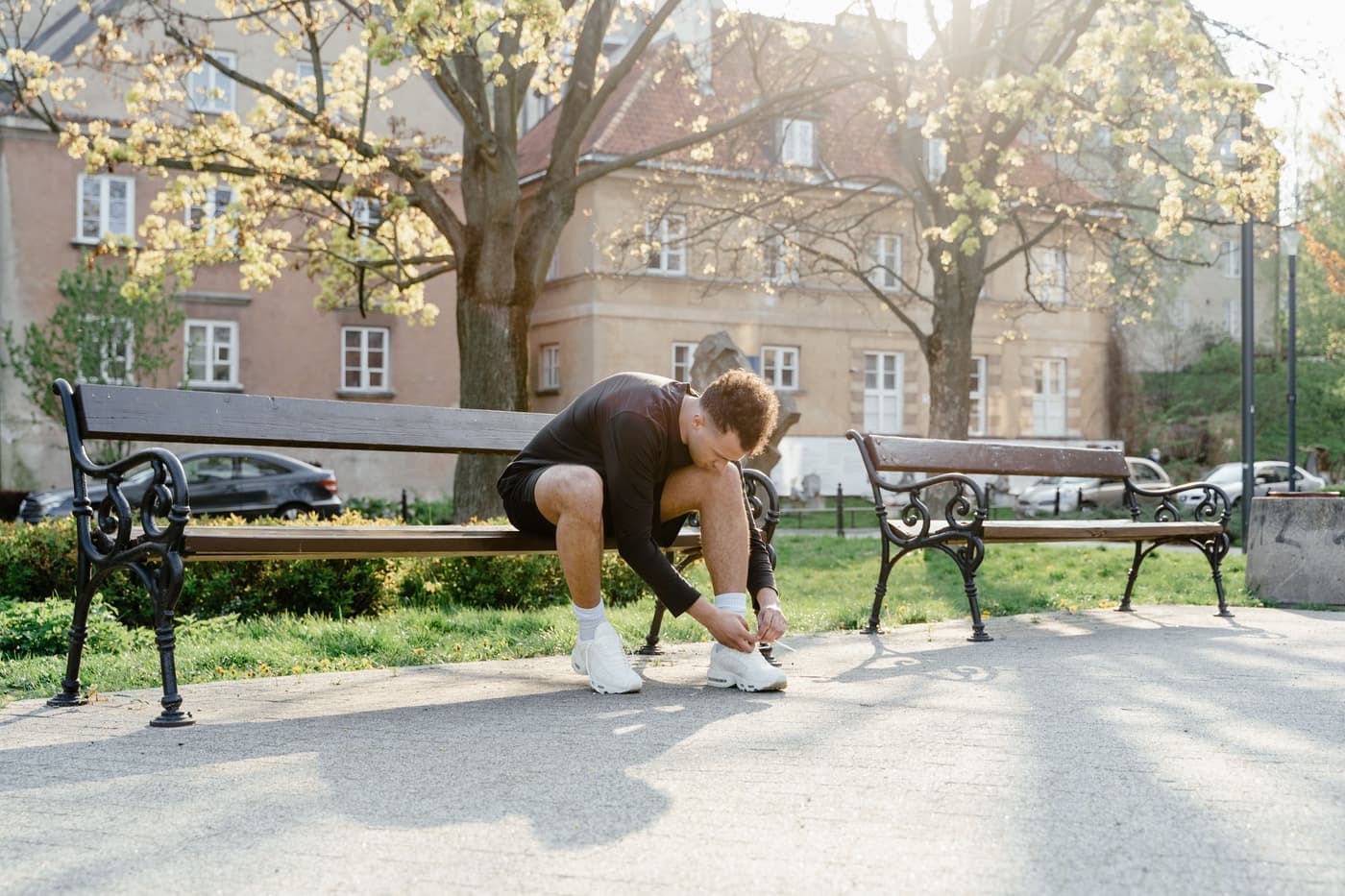 A person sitting on a bench putting shoes on