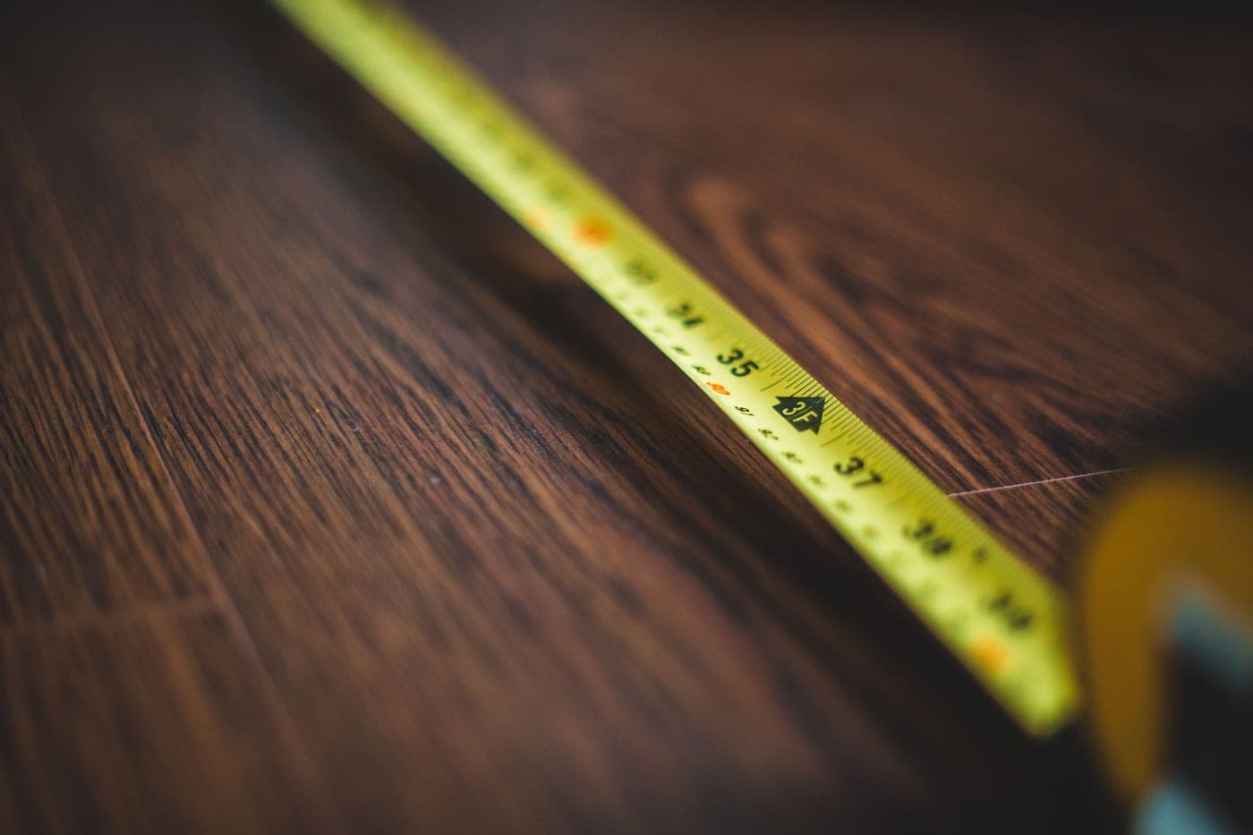A tape measure extended across a wooden surface