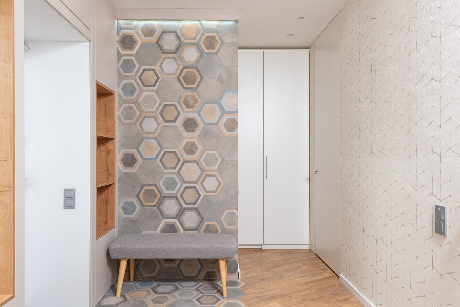 A modern entrance lobby with a closet, a door and an upholstered bench