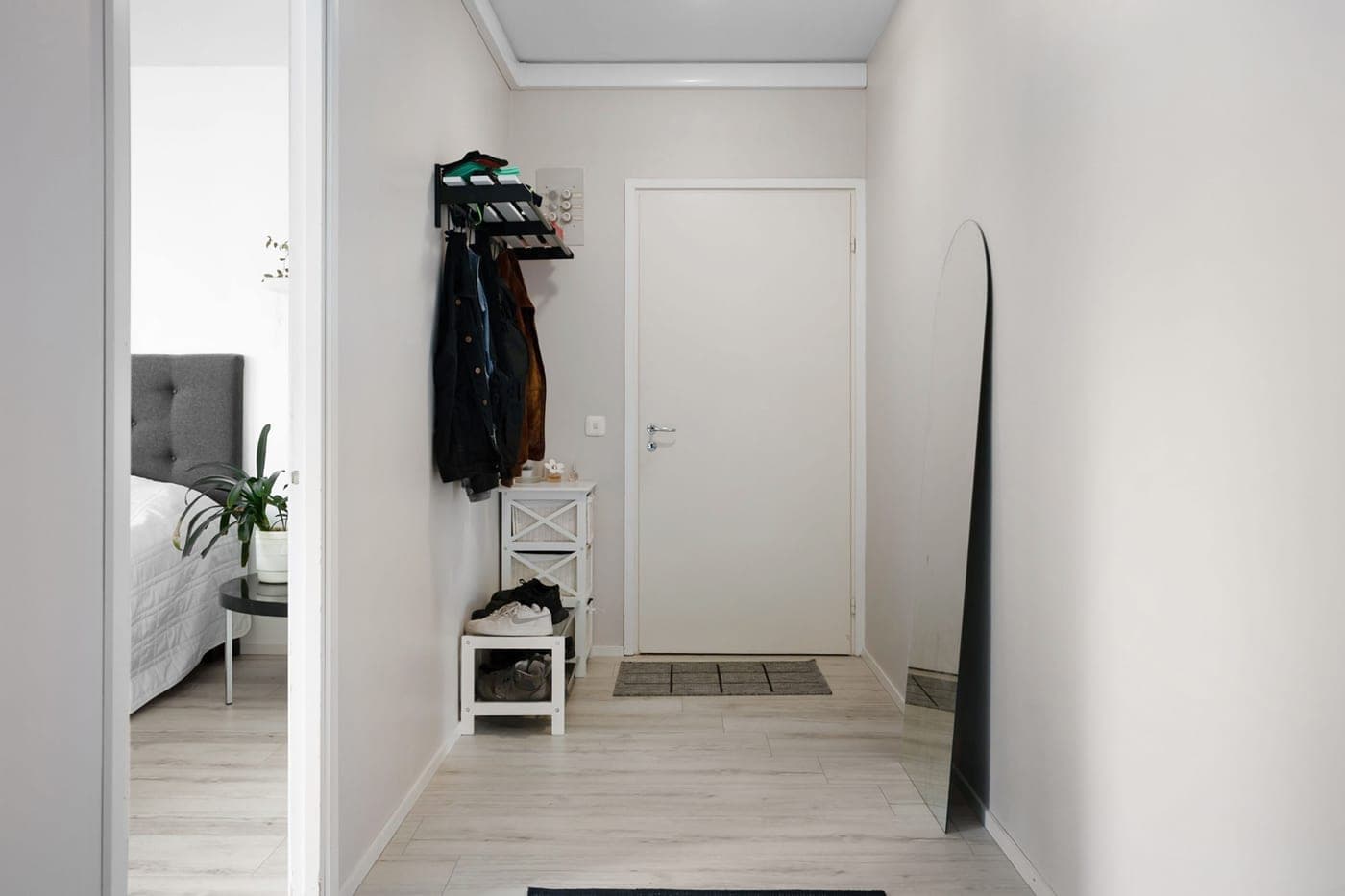 A tall shoe storage unit standing against a hallway wall