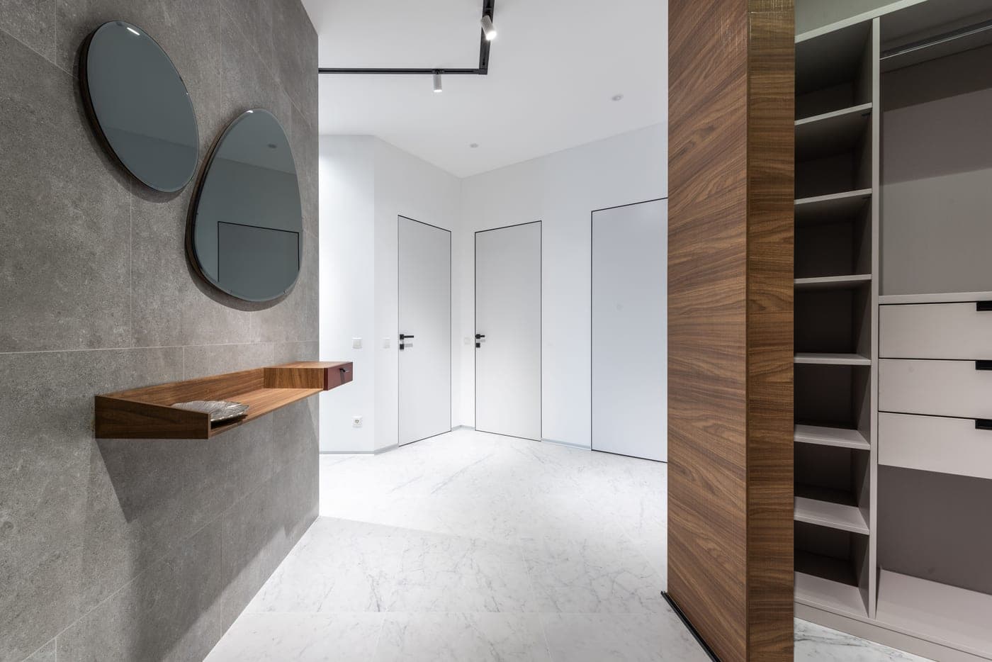 A contemporary hall with a wooden shelf against a large closet